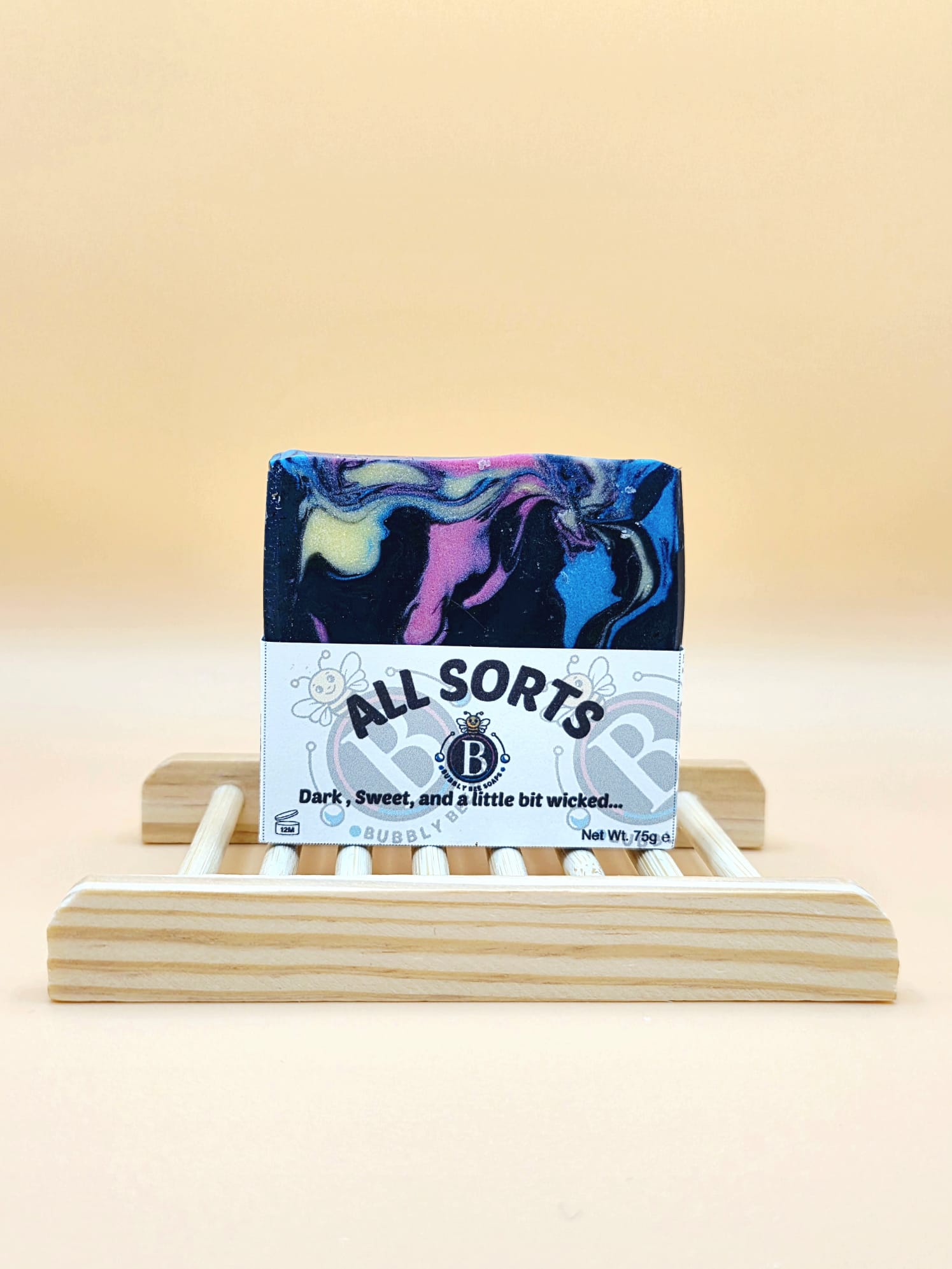 Colorful soap bar with 'All Sorts' packaging on a wooden stand against a beige background